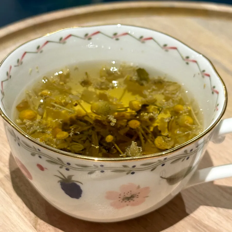 A cup of chamomile tea with the flowers floating